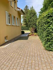 een stenen loopbrug naast een gebouw met een heg bij Ferienhaus Marina in Soltau