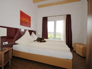 un orsacchiotto che giace su un letto in una camera da letto di Mittagsgold a Colmberg