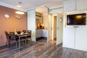 霍尔斯泰因地区诺伊斯塔特ancora Marina Haus 1 Nr 06, Typ 2的带桌椅的餐厅和厨房