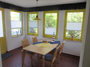 ein Esszimmer mit Tisch und Stühlen und Fenstern in der Unterkunft Franzi 3 in Prerow