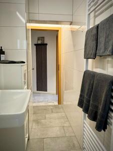 オスナブリュックにあるCity Apartment Osnabrück -- inklusive Parkplatz & WiFi, vollausgestattete Küche mit Geschirrspüler -- Perfekt für Urlaub & Businessの洗面台とシャワー付きの白いバスルーム