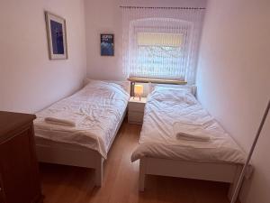 two beds in a small room with a window at Apartament Złota Woda in Głuszyca +2 photos