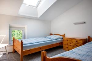 a bedroom with two beds and a dresser and a window at Knusthof - Wohnung 4 in Albertsdorf