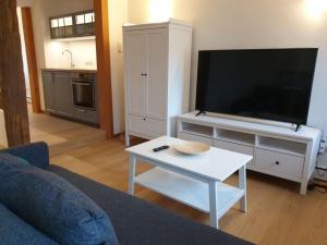 a living room with a flat screen tv and a table at Torhaus Rattelsdorf - Wohnung 3 Lilie in Rattelsdorf