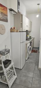a kitchen with a white refrigerator and a washing machine at Appartamento Mare Verde Bambù in Martinsicuro