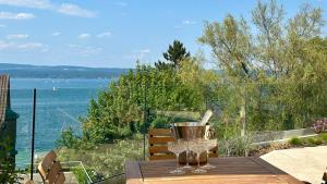 a table with wine glasses and a view of the water at LAKEVIEW - 2 bedroom stay with Sauna and parking on Lake Constance in Berlingen