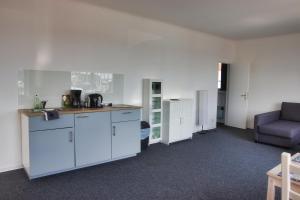 an empty room with a kitchen and a couch at Alte Segelschule in Lübeck