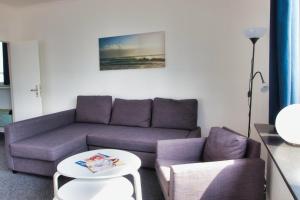 a living room with a purple couch and a table at Alte Segelschule in Lübeck