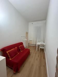 フェラーラにあるRipa Grande Apartmentの赤いソファとテーブルのあるリビングルーム