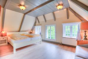 una camera con un letto bianco e due finestre di S1 im Friesenhaus Sara a Wenningstedt