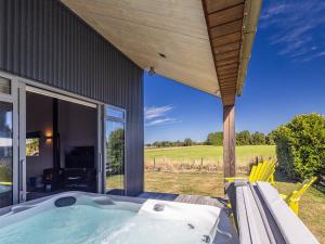 a house with a jacuzzi outside of it at Ohakune Holiday Home Retreat with Hot Tub in Ohakune