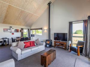 a living room with a couch and a tv at Ohakune Holiday Home Retreat with Hot Tub in Ohakune