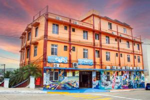 a large orange building with graffiti on it at Hotel Cortaza Galería in Coatzacoalcos