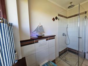 un bagno con doccia e una barchetta giocattolo su un bancone di Ferienhaus Ostseeblick Schönhagen a Brodersby