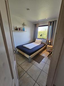 una camera da letto con un letto in una stanza con una finestra di Ferienhaus Ostseeblick Schönhagen a Brodersby Altre 16 foto