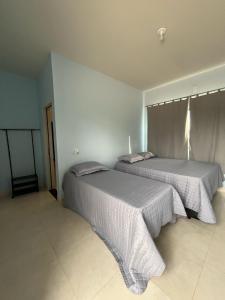 two beds sitting in a room withermottermottermott at Chácara Manacá da Serra in São Roque de Minas