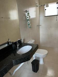 a bathroom with a sink and a toilet at Chácara Manacá da Serra in São Roque de Minas