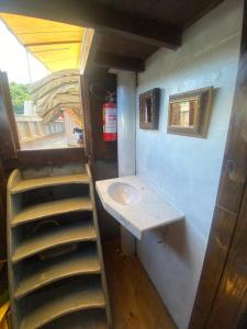 Un pequeño baño con lavabo y escalera. en Escuna Costa Verde I para passeios durante o dia, en Paraty