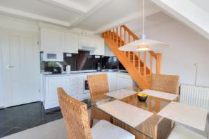 a kitchen and dining room with a table and chairs at Abaco 3N in Wenningstedt