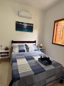 Un dormitorio con una cama con una manta azul y blanca. en Casa Lua, en Isla de Boipeba