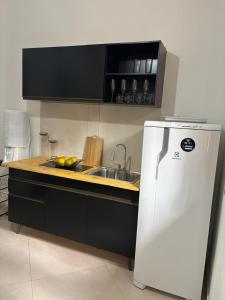una cocina con fregadero y refrigerador en Casa Lua, en Isla de Boipeba