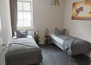 a bedroom with two beds and a window at Apartment Kapstadt Garten & Poolnutzung als Extra möglich in Mühlhausen