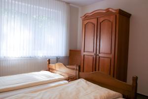 a bedroom with two beds and a wooden cabinet at Familienhof Brüning - Terrassenwohnung in Meppen