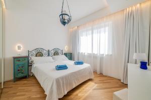 a bedroom with a white bed with blue towels on it at Appartamento al Mare in Taormina