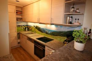 a kitchen with a mural of a farm on the wall at Alpenspatzl in Reit im Winkl