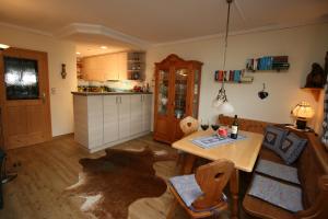 a kitchen with a wooden table and a table and chairs at Alpenspatzl in Reit im Winkl +15 photos