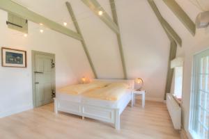 una camera da letto con letto bianco in mansarda di S2 im Friesenhaus Sara a Wenningstedt