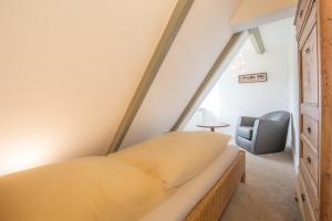 una camera da letto con un letto e una sedia di S2 im Friesenhaus Sara a Wenningstedt