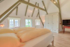 una camera da letto con un letto grande in una mansarda di S2 im Friesenhaus Sara a Wenningstedt