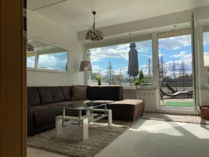 een woonkamer met een bank en een glazen tafel bij Ferienwohnung Harz #3, Pool, Sauna, WLAN in Hohegeiß