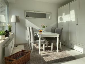 een eetkamer met een witte tafel en stoelen bij Ferienwohnung Harz #3, Pool, Sauna, WLAN in Hohegeiß