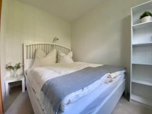 een bed met witte lakens en kussens in een slaapkamer bij Ferienwohnung Harz #3, Pool, Sauna, WLAN in Hohegeiß