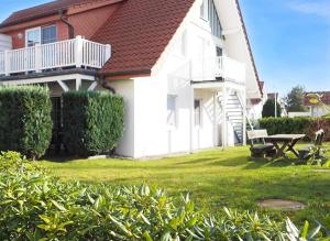 a white house with a picnic table in the yard at FeWo "Stems - W5" in Prerow +9 photos