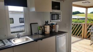 a kitchen with a sink and a counter top at Campingland Ostsee - Mobilheim 016Weitsicht in Schashagen