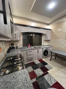 アンマンにあるSweet Home In Ammanのシンクとコンロのあるキッチン トップオーブン
