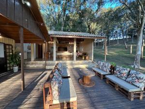 a porch with benches and a table on a house at Aconchego e Refúgio no Campo in Contenda