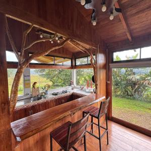 a kitchen with two chairs and a large window at Refugio del Bosque in Guácimo