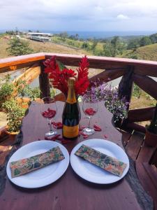 a table with two plates and a bottle of wine at Refugio del Bosque in Guácimo +34 photos