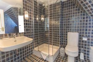 un bagno piastrellato blu con un water e un lavandino di F2 im Haus am Meer a Wenningstedt