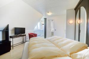 un soggiorno con un divano e una televisione di F2 im Haus am Meer a Wenningstedt