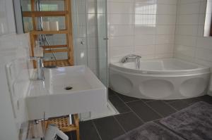 a white bathroom with a tub and a sink at Ferienwohnung Fam Wernicke in Preußisch Oldendorf