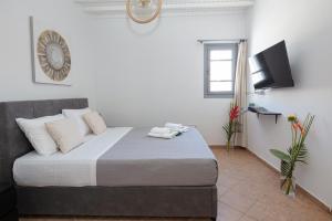 a bedroom with a large bed with white walls at Aristeas Studio in Ornos