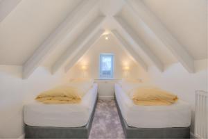 two beds in a room with a roof at Abaxie A in Wenningstedt