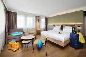 a hotel room with a bed and a table and chairs at Moxy Annecy in Annecy