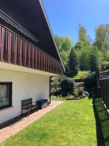 a bench next to a building with a grass yard at Ferienhaus Korn in Bruchweiler-Bärenbach