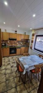 a kitchen with a table and chairs and a table and a window at Ferienhaus Korn in Bruchweiler-Bärenbach +17 photos